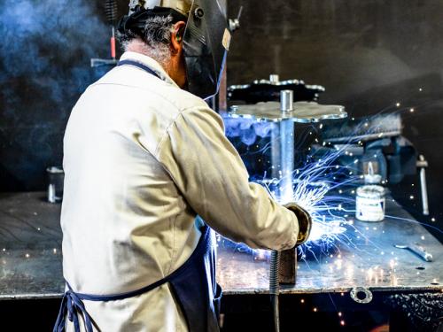 Manufacturing worker welds